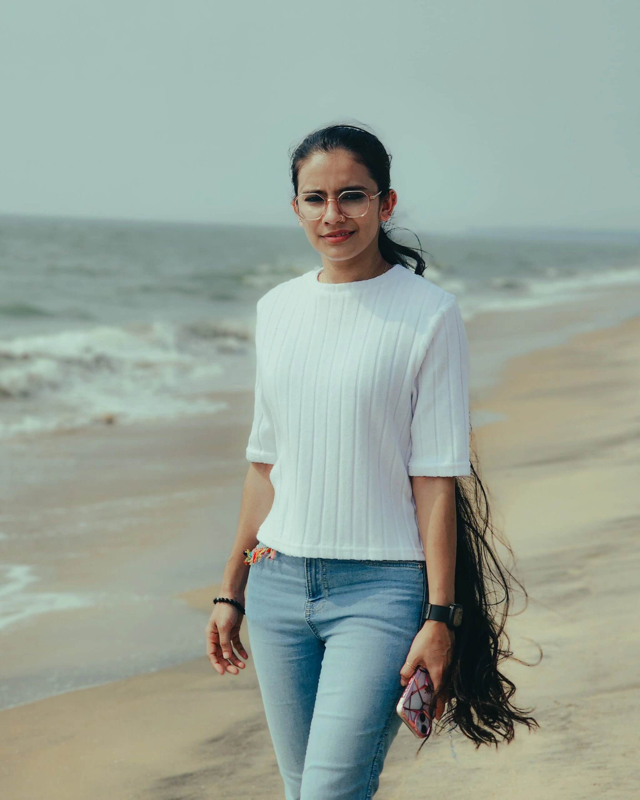 Best tDigital marketing expert in Calicut standing confidently on the beach in a casual white top and jeans, showcasing a relaxed and professional vibe